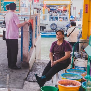 A stallowner minding her live fish in the buckets, Tai-O, Hong Kong